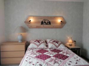 a bedroom with a bed with a quilt on it at L'encantador in Saint-Mamet