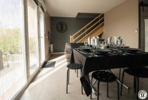 a dining room with a black table and chairs at La maison d'emy in Vernet
