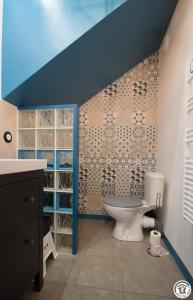 a bathroom with a toilet and a blue wall at La maison d'emy in Vernet +20 photos