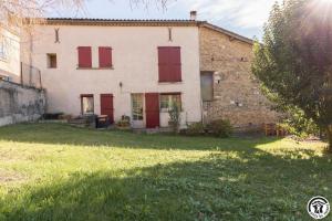an old stone house with red doors and a yard at Gîte les ecureuils in Montclar-de-Comminges