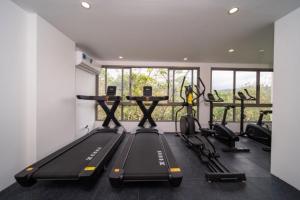 un gimnasio con cintas de correr y una fila de bicicletas estáticas en 全新现代风格 魅力泳池公寓, en Kamala Beach