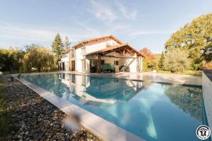a swimming pool in front of a house at Villa la sauzière in Buzet-sur-Tarn