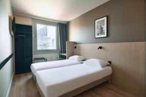 a hotel room with two beds and a window at Premiere Classe Warszawa Centrum in Warsaw