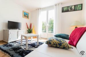 a living room with a couch and a tv at Vacances garonne toulouse in Saubens