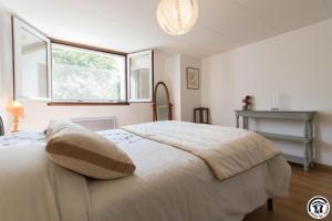 a bedroom with a large white bed with a window at Vacances garonne toulouse in Saubens
