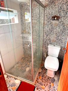 a bathroom with a toilet and a glass shower at APTO 08 min a PÉ, Praia Taperapuan! Piscina! Estacionamento Grátis! in Porto Seguro +35 photos