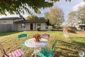a table and chairs in the yard of a house at Le clos bleu in Gauré