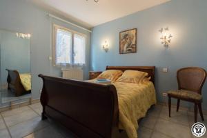 a bedroom with a bed and a chair and a window at Le clos bleu in Gauré