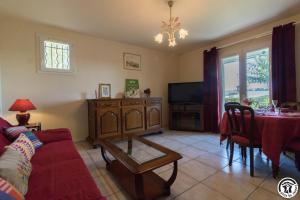 a living room with a couch and a table at Le clos bleu in Gauré