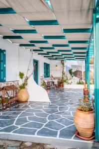 a patio with blue beams and potted plants at Seaside Apartments in Adamantas
