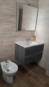 a bathroom with a sink and a toilet and a mirror at Apartment A&D Home Imola Centro in Imola +13 photos