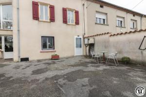 a house with two chairs and a table in front of it at Comà a l'ostal in Montégut-Lauragais