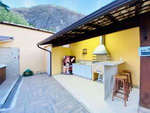 una cucina con pareti gialle e una cucina con piano cottura di Casa Jacuzzi Piscina Churrasqueira 10 min Itaipava a Inglesa