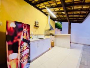 una cucina con una bottiglia di soda sul frigorifero di Casa Jacuzzi Piscina Churrasqueira 10 min Itaipava a Inglesa