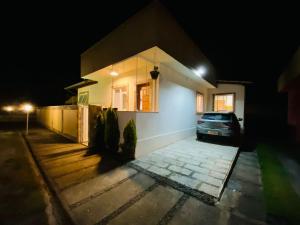 un'auto parcheggiata di fronte a una casa di notte di Casa Jacuzzi Piscina Churrasqueira 10 min Itaipava a Inglesa