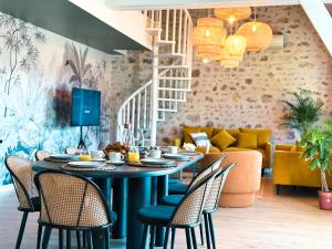 a dining room with a table and chairs and a couch at Le Golf Comme Jardin Dormez au Cœur du Parcours in Lésigny