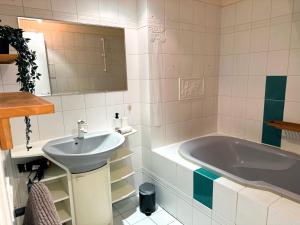 a bathroom with a sink and a tub at Le Golf Comme Jardin Dormez au Cœur du Parcours in Lésigny +16 photos