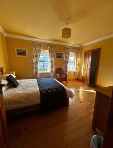 a bedroom with a bed and a chair in a room at Yewwood Cottage in Newry