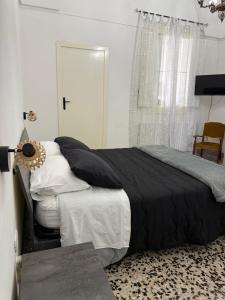 a bedroom with a bed with black sheets and a window at MiMì House in Nardò