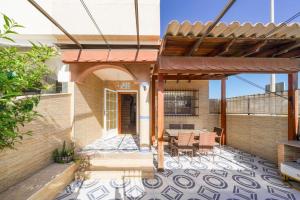 a house with a patio with a table and chairs at 4-Bed Villa Sleeps 8 Pets Ok & 10 min to Beach in Los Alcázares