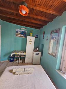 a room with a bed with a table and a refrigerator at LaLaLand in Mikonos