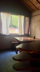 a room with a table and a window at Casitas del arroyo Actividades Arte Cultura y descanso en Villa General Belgrano in Villa General Belgrano +4 photos