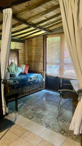 a bedroom with a bed and a chair in a room at Casitas del arroyo Actividades Arte Cultura y descanso en Villa General Belgrano in Villa General Belgrano