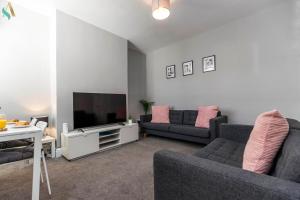 Una sala de estar con dos sofás y un televisor de pantalla plana. en Eton House - TSAC, en Stockton-on-Tees