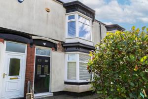 una casa con una puerta blanca y un árbol en Eton House - TSAC, en Stockton-on-Tees