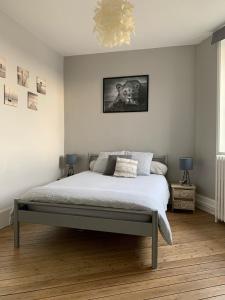 a bedroom with a bed and a chandelier at Villa Volclair Spacieux Duplex à 50m de la plage in Mers-les-Bains