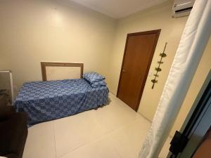 a small bedroom with a bed and a door at Hospedaria HAPPY in Salinópolis