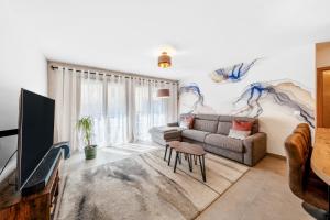 a living room with a couch and a tv at Appartment hypercentre Evian in Évian-les-Bains