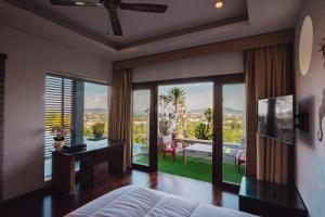 Un dormitorio con una cama y vista a un patio. en Chalong Sunset Villa, en Chalong 