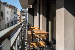 two wooden chairs sitting on a balcony of a building at Appartment hypercentre Evian in Évian-les-Bains
