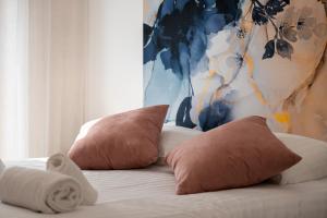 a bed with two pillows and a painting at Appartment hypercentre Evian in Évian-les-Bains
