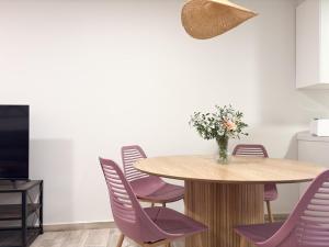 a dining room with a wooden table and purple chairs at ChillaHomes 102 in Candeleda +8 photos