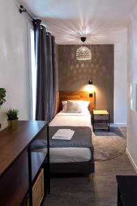 una camera da letto con un letto e una scrivania di Hôtel Lodge In Paris 13 a Parigi Altre 37 foto