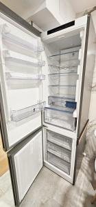 an empty refrigerator with its door open in a kitchen at Vacansis Habitaciones y Alojamientos A Coruña in Visma