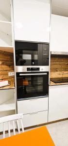 a kitchen with an oven in a white cabinet at Vacansis Habitaciones y Alojamientos A Coruña in Visma +98 photos