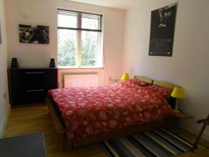 a bedroom with a red bed and a window at Modern and stylish flat in London