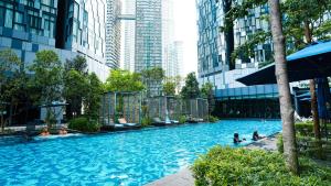 a swimming pool in a city with people in it at Star KLCC Twin Tower Cozy 2-3pax by DingDing in Kuala Lumpur