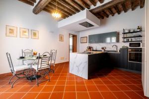 a kitchen with an orange tile floor and a table at Homeby, Villa Corte dello Zanchino in Zola Predosa