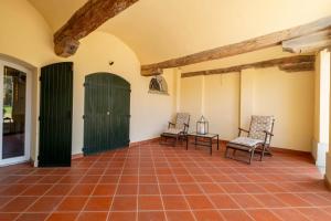 a room with two chairs and a green door at Homeby, Villa Corte dello Zanchino in Zola Predosa