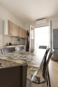 a kitchen with a large table with chairs and a dining room at Centonze appartamenti in San Foca