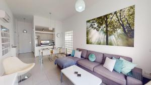 ein Wohnzimmer mit einem lila Sofa und einer Küche in der Unterkunft Casa de las Sonrisas - An MHR Property in Torre-Pacheco