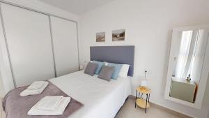 ein weißes Schlafzimmer mit einem Bett mit Handtüchern darauf in der Unterkunft Casa de las Sonrisas - An MHR Property in Torre-Pacheco + 17 Fotos