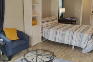 Un dormitorio con una cama, una silla y una mesa de cristal. en Cozy Corner, en Caryville