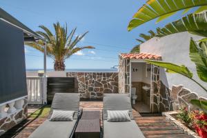 a patio with chaise lounges in front of a house at Paraíso Radazul in Radazul