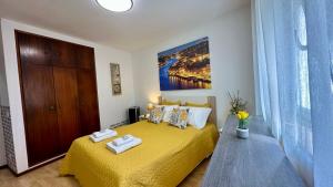ein Schlafzimmer mit einem gelben Bett mit Handtüchern darauf in der Unterkunft Almeida's House by Férias em Figueira in Figueira da Foz