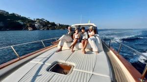 un grupo de personas sentadas en la parte trasera de un barco en AIR OF SEA ON BOAT, en Salerno